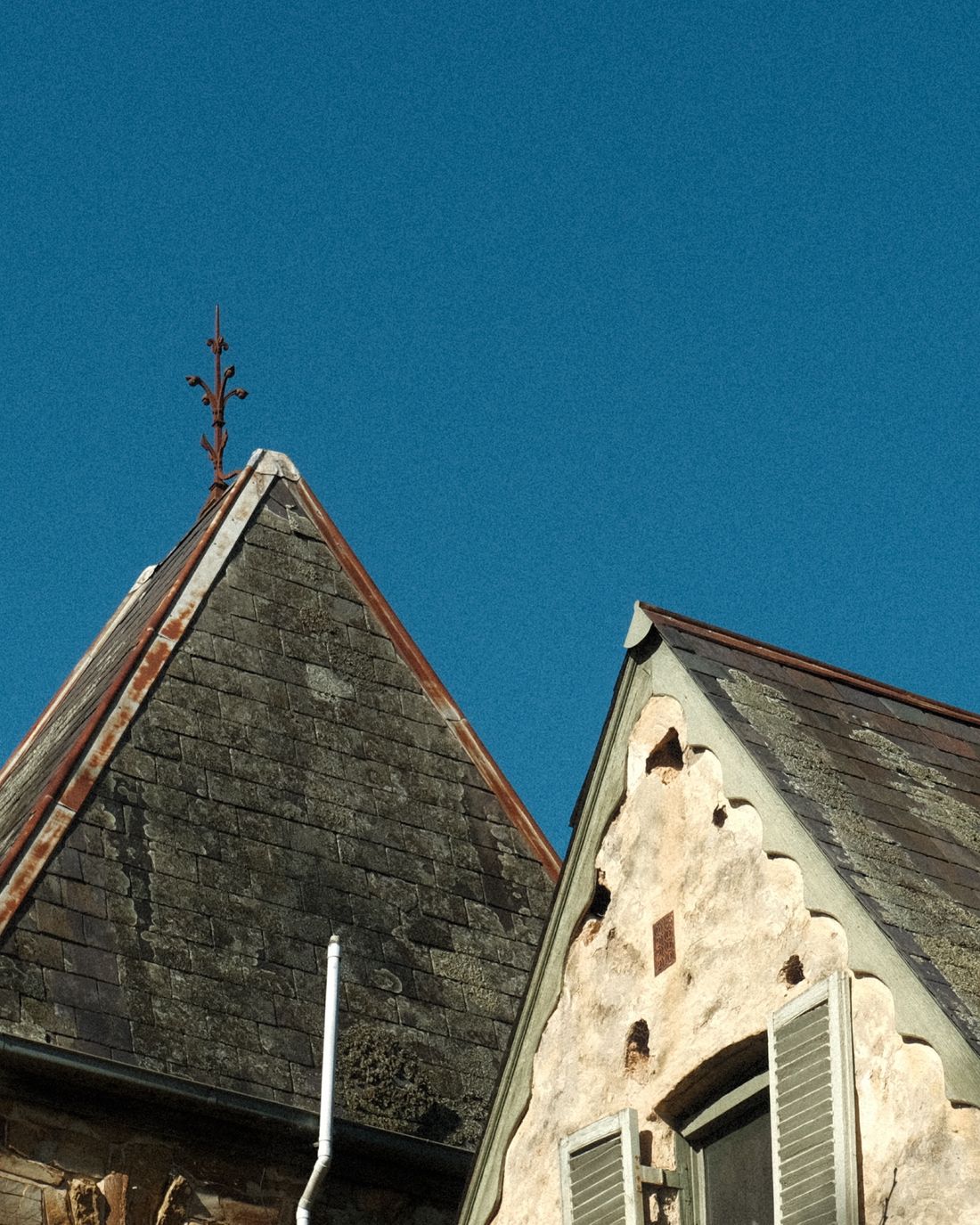 Toiture ardoise et épi de faîtage contre ciel bleu
